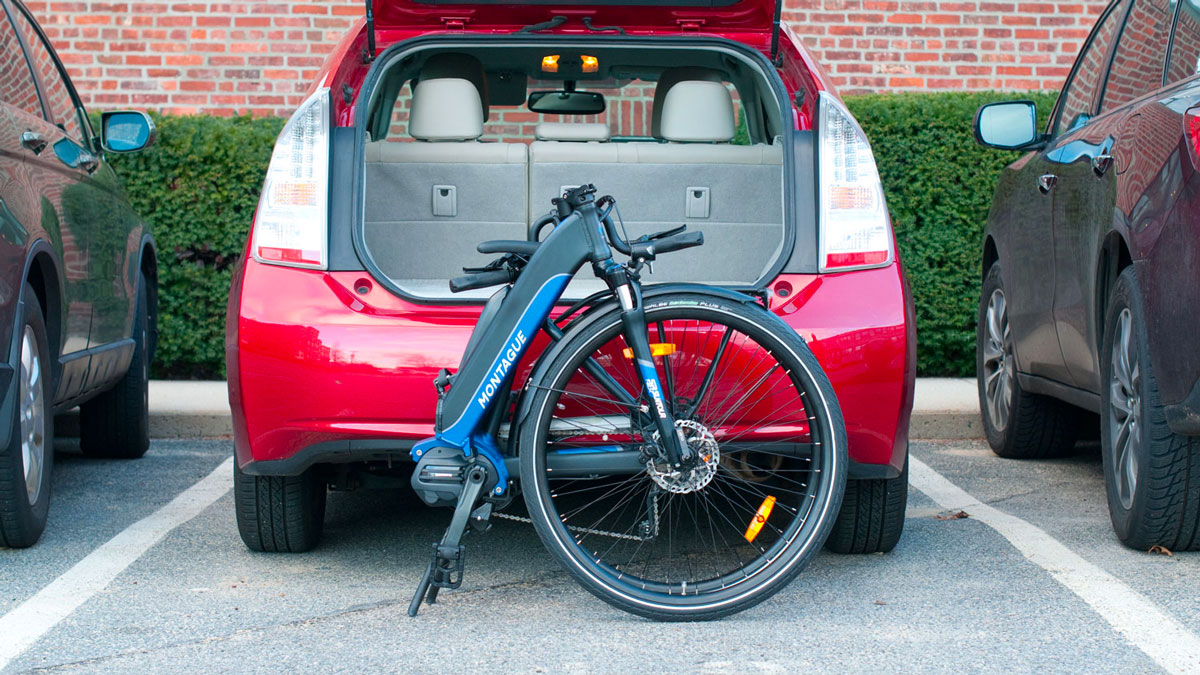 vélo montague ME-1 plié devant un coffre de voiture